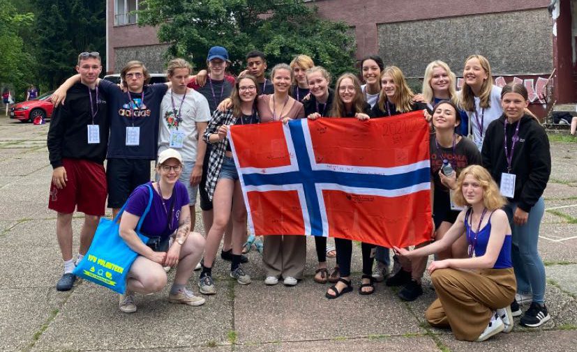 Gruppenfoto von Jugendlichen mit einer Norwegenfahne in der Mitte